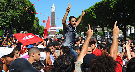 Människor demonstrerar i Tunisien. Foto: Hassene Dridi/Scanpix.